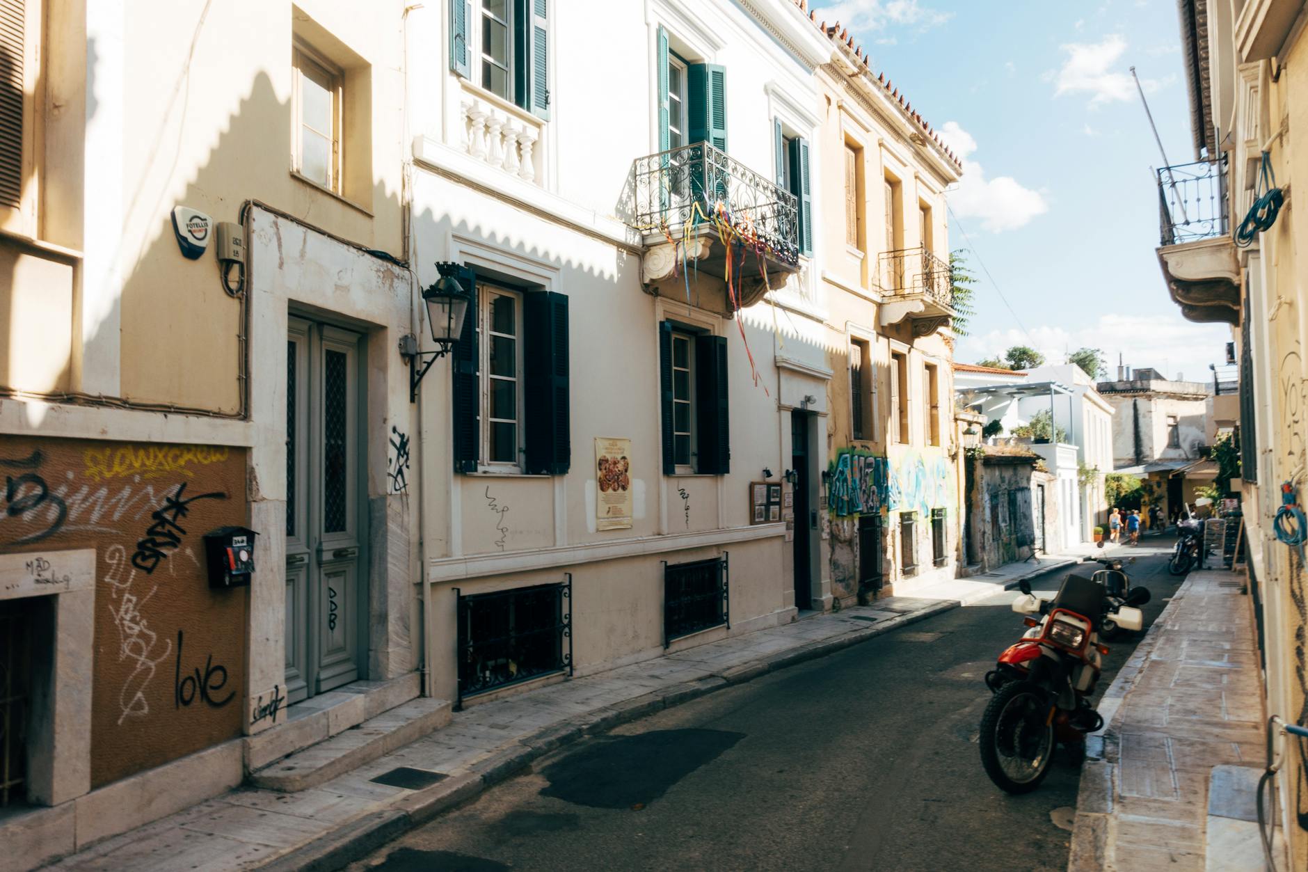 Vista de las calles del barrio de Plaka en Atenas con la Acrópolis al fondo